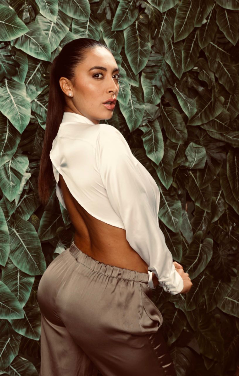 Editorial portrait — ivory silk shirt against tropical greenery
